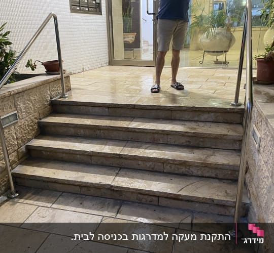 התקנת מעקות ומאחזי יד ממתכת בגרם מדרגות כניסה לבניין
